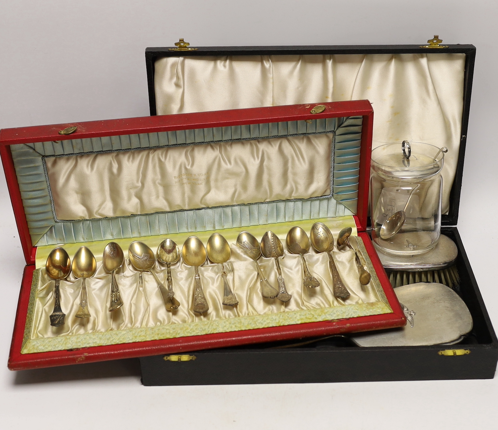 An Elizabeth II cased silver mounted three piece mirror and brush set, with RAF wings applique, twelve sterling spoons and a silver mounted glass preserve jar.